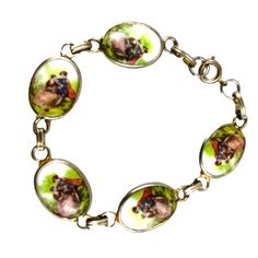 This exquisite Fragonard vintage bracelet features hand-painted porcelain cameos depicting an enchanting romantic scene. Each cameo is delicately encased in a gold-tone setting and linked together to form an elegant chain. Ideal for a sophisticated accessory or a charming gift, this bracelet combines timeless beauty with intricate craftsmanship. * Hand-painted porcelain cameos * Gold-tone settings * Romantic scene artwork * Linked chain design * Secure clasp closure * Vintage craftsmanship 7 inc Vintage Oval Gold Bracelet As Gift, Vintage Oval Gold Bracelet Gift, Vintage Oval Gold Bracelet For Gifts, Antique Enamel Bracelets As Gift, Antique Enamel Bracelets For Gifts, Vintage Cabochon Bracelets As Gift, Cameo Bracelet, Retro Bracelet, Romantic Scenes