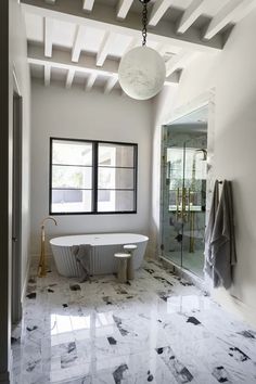 a bathroom with marble floors and white walls