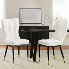 two white chairs sitting at a black table