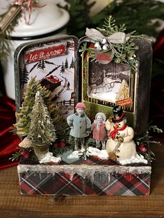 an old fashioned christmas scene is displayed in front of a white candle and evergreen tree