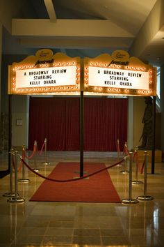 a red carpeted area with barriers and signs