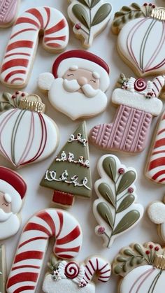 christmas cookies decorated like santa clause and candy canes on a white surface with gold trimming