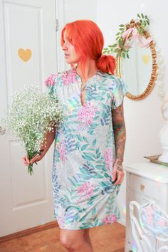 Details: The perfect summertime lounging piece is simple, lightweight, and soft on the skin; the nightgown is made of a unique nylon material printed with blue and teal leaves and magenta flowers. This material gives an earthy, almost fairy vibe. The neckline has a single button with a keyhole cut out, giving it a deep v in the neckline.  Brand: Vanity Fair Size: Small - The model is 5'3" with a 32A bust. Condition:  Excellent condition  Material: 100% Nylon *Please note - Signs of wear are typi Green Summer Nightgown For Sleepover, Green Short Sleeve Summer Nightgown, Green Summer Nightgown, V-neck Summer Sleepwear For Hospital, Summer Floral Print Nightgown, Blue Short Sleeve Nightgown For Summer, Summer Hospital Nightgown With Short Sleeves, Fairy Vibe, Magenta Flowers