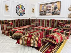 a large couch made out of many different pieces of fabric on the floor in front of a clock