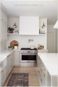 a kitchen with white cabinets and gold accents