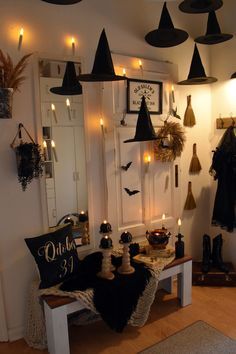 a room filled with lots of witches hats hanging from the ceiling and candles on the wall