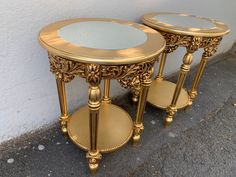 two gold side tables with mirrors on them