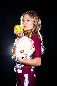 a young woman holding a softball and glove