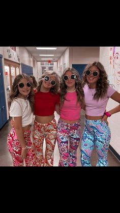 three girls in matching pants and sunglasses posing for the camera