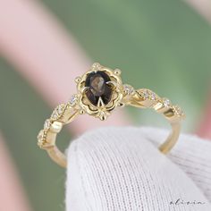 a close up of a gold ring with a brown stone in it's center