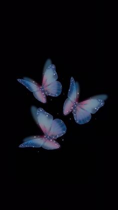 three blue butterflies flying in the dark with water droplets on their wings and back side