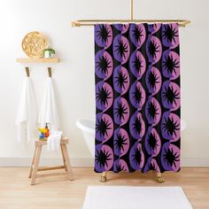 a purple and black shower curtain hanging on a wall next to a white bath tub