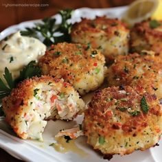 crab cakes on a white plate with lemon wedges