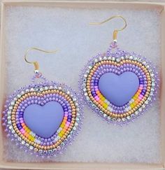 a pair of earrings with beaded hearts in the shape of a rainbow and blue heart