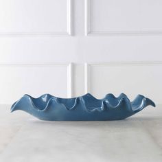 a blue bowl sitting on top of a white counter next to a wall and door