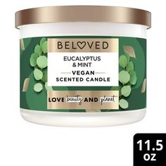 a jar of scented candles with green leaves on the lid and label below that reads, beloved