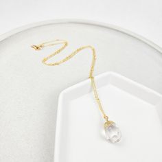 This special necklace features a stunning faceted quartz gemstone drop pendant. The sturdy, yet delicate 18k tarnish-resistant gold-plated satellite chain is 24" long and is dotted with tiny gold beads. Thanks to the beautiful variation of the natural stones, the color tone of the gemstone may vary slightly from the photo. Each crystal is perfectly unique! Gold Drop Crystal Necklace With Gemstone, Gold Teardrop Gemstone Crystal Necklace, Gold Faceted Drop Necklace, Gold Faceted Briolette Drop Necklace, Gold Drop Jewelry With Faceted Beads, Gold Faceted Briolette Crystal Necklace, Gold Crystal Dangle Necklaces With Faceted Beads, Gold Teardrop Crystal Necklaces With Adjustable Chain, Gold Teardrop Crystal Necklace With Adjustable Chain