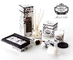 an assortment of candles and soaps are displayed in front of a black and white box