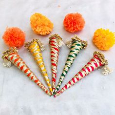 six decorative candy cones with pom poms on them