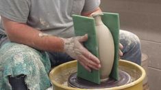 a man is making a vase out of clay