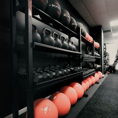 there are many exercise balls on the shelves in this gym room, and one is full of dumbbells