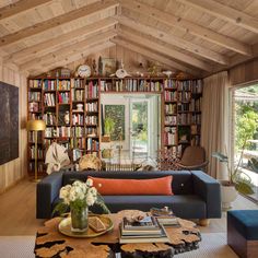 a living room filled with lots of books and furniture