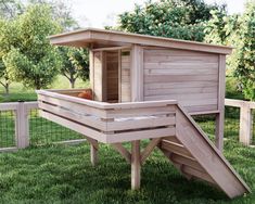 a small wooden chicken coop in the grass with a slide on it's side