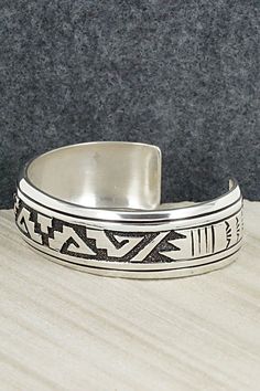 This sterling silver bracelet featuring a traditional Navajo pattern was made by Navajo silversmith Rosita Singer. The back is signed T&R Singer and stamped sterling.Size: 5 1/2" (will fit a 6 3/4" wrist)Gap: 1 1/4"Length: 3/4"Free shipping on all orders! We ship with USPS and always include tracking. All orders ship within a day of payment.Returns are accepted up to 30 days after you receive your order. Just send us a message. Our shop offers cash back or store credit. The item must be returned Adjustable Silver Southwestern Bangle, Adjustable Southwestern Silver Bangle, Southwestern Silver Cuff Bracelet With Inlay, Etched Sterling Silver Bracelet In Traditional Style, Traditional Etched Sterling Silver Bracelet, Adjustable Etched Sterling Silver Southwestern Bracelet, Adjustable Etched Southwestern Sterling Silver Bracelet, Southwestern Sterling Silver Stamped Bangle Bracelet, Traditional Sterling Silver Etched Cuff Bracelet