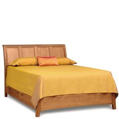 a wooden bed with yellow sheets and pillows