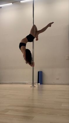 a woman is doing acrobatic tricks on a pole