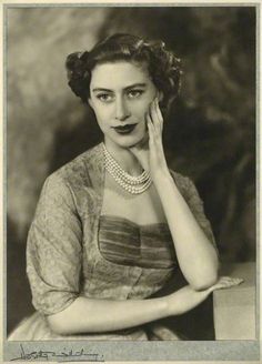 an old black and white photo of a woman with her hand on her face,