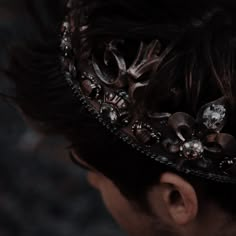 a close up of a person wearing a tiara with flowers on it's head