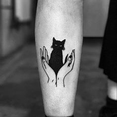 a black and white photo of a person holding a cat on their left leg with both hands