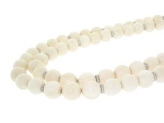 Pallid perfection, this elegant off-white bone bead and diamond necklace is a unique choice for an evening affair. Perfectly rounded beads of creamy bone are spaced as trios that alternate with shimmering diamond rondelles. This pre-owned necklace does not have a clasp. Luxury White Necklaces With Polished Beads, Luxury White Necklace With Polished Beads, Luxury White Polished Bead Necklaces, White Elegant Formal Beads, Elegant Cream Necklaces With Large Beads, Elegant White Beads For Formal Occasions, Elegant Large Rondelle Beads, Luxury White Beaded Necklaces With Round Beads, Elegant Cream Jewelry With Large Beads