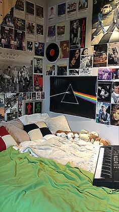 a bed in a room with pictures on the wall and a laptop sitting on top of it