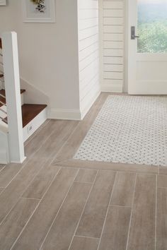 a white door and some stairs in a room with wood flooring on the walls