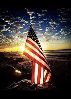 an american flag on the beach at sunset