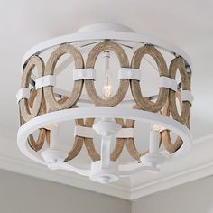 a chandelier hanging from the ceiling in a room with white trim and wood circles