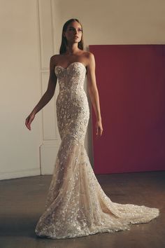 a woman in a wedding dress posing for the camera with her hand on her hip