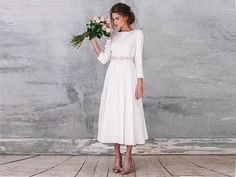 a woman in a white dress holding flowers