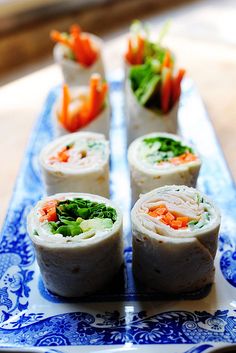 there are several rolls on the table with carrots and lettuce in them