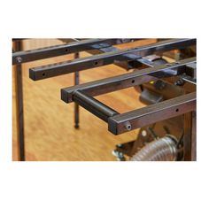 three metal brackets are attached to the side of a wooden table with wheels on it