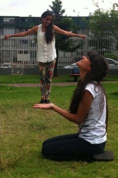 two girls are playing frisbee in the grass