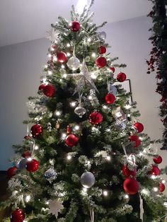 a white christmas tree with red and silver ornaments