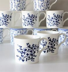 blue and white coffee cups are stacked on top of each other