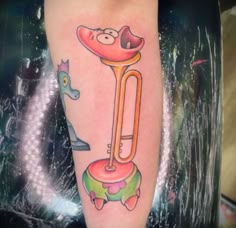 a person with a tattoo on their leg has a cartoon character holding a large tube