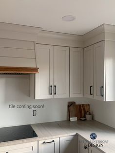 an empty kitchen with white cabinets and counter tops is pictured in this image, the words title coming soon