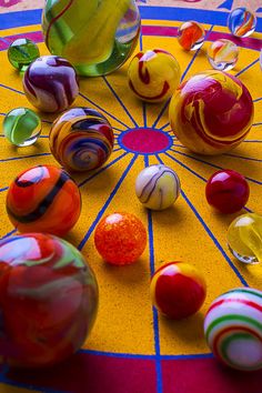 an assortment of marbles sitting on top of a colorful board game table with circles