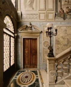 an entry way with stairs and paintings on the walls