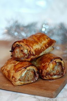 two sausage pastries on a wooden cutting board